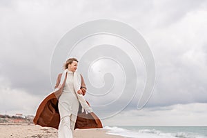 Blond woman Christmas tree sea. Christmas portrait of a happy woman walking along the beach and holding a Christmas tree