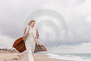 Blond woman Christmas tree sea. Christmas portrait of a happy woman walking along the beach and holding a Christmas tree