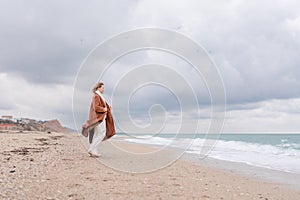 Blond woman Christmas tree sea. Christmas portrait of a happy woman walking along the beach and holding a Christmas tree