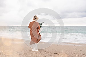 Blond woman Christmas tree sea. Christmas portrait of a happy woman walking along the beach and holding a Christmas tree