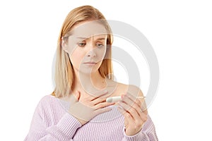 Blond woman with a clinical thermometer. She has fever. She caught the virus.