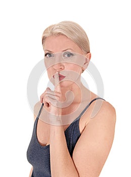 Blond woman in close-up with finger over mouth