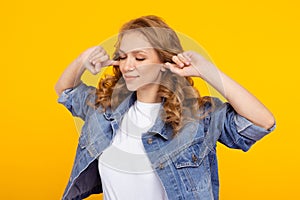 Blond woman closing her ears standing in the studio alone.