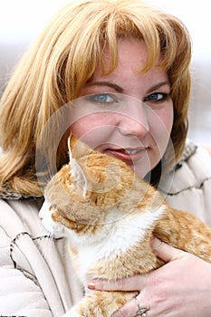 Blond woman cuddling cat
