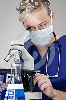 Blond Woman Doctor Using Microscope