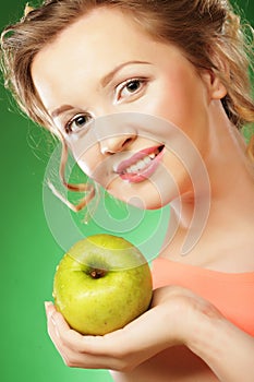 Blond woman eat green apple over green background