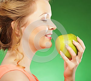 Blond woman eat green apple over green background