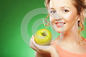 Blond woman eat green apple over green background