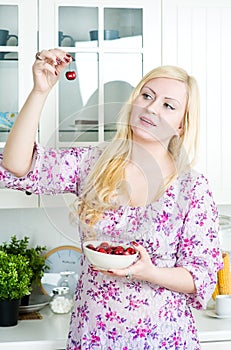 Blond woman eating cherry
