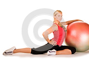 Blond woman exercising with a pilates ball