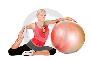 Blond woman exercising with a pilates ball