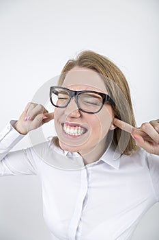 Blond woman in glasses with fingers in ears