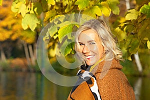 Blond woman in her 40s outdoors enjoying the autumn sun