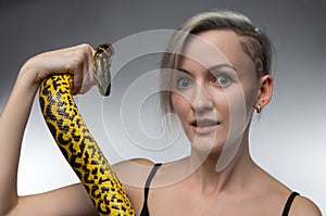 Blond woman holding yellow snake