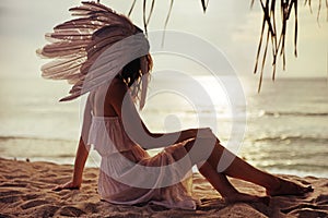 Blond woman with a huge plume watching the sunset