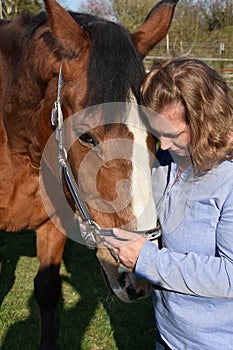 Blond woman hugs her  horse