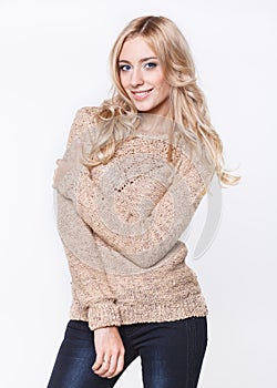 Blond woman in jeans and a beige sweater