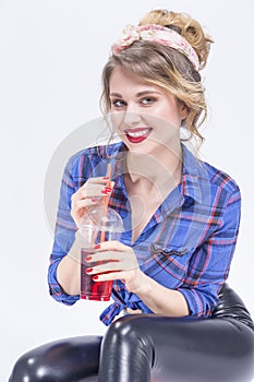 Blond Woman in latex pants Posing with Cup of Red Juice and Straw.
