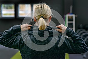 Blond woman lifting the hood of a top