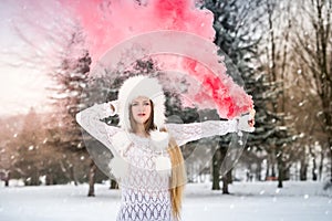 Blond woman with long hair holding smoke bomb