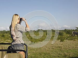 Blond Woman Looking Through Binoculars In Jeep