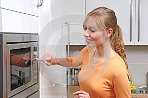 Blond woman with a microwave
