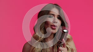 Blond Woman sings in studio in retro microphone