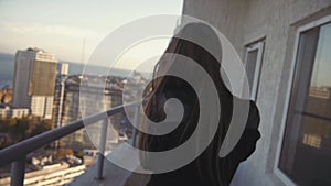 Blond Woman Smoking Basking in Blanket on High Floor at Buildings Background