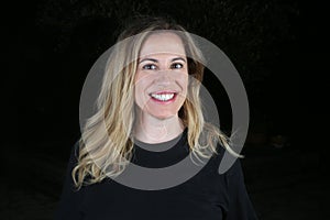 Blond woman studio portrait with black background