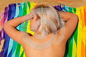 Blond woman sunbathing topless