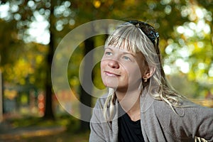 Blond woman with sunglasses portrait in a autumn park.