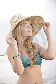 Blond woman with sunhat on the beach