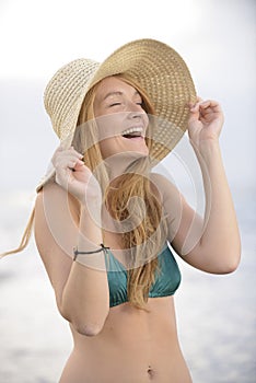 Blond woman with sunhat on the beach photo