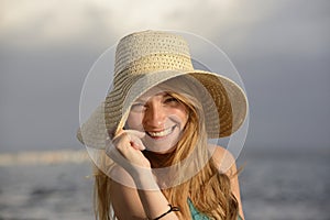 Blond woman with sunhat on the beach