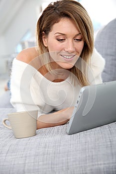 Blond woman with tablet websurfing