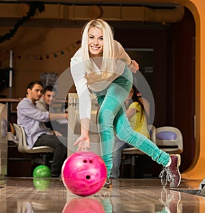 Blond woman throwing bowling ball