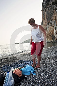 A blond woman about to leave the beach at sunset. Cove.