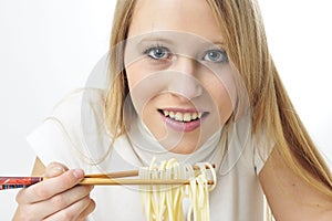 Blond woman use chopsticks eating noodles