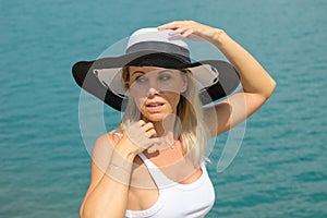 Blond woman wearing a black and white summer hat