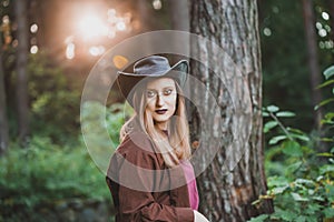 Blond woman wearing cowboy hat and brown shirt