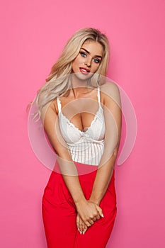 Blond Woman In White Corset And Red Trousers