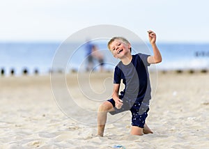 Blond young boy enjoying a beach.