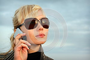 Blond young girl on background blue sky