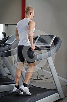 Blond young man running on treadmill