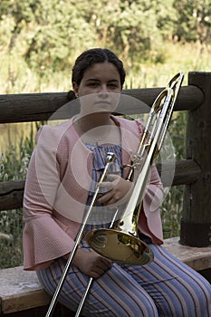 Blond young woman playing the trombone