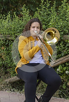 Blond young woman playing the trombone