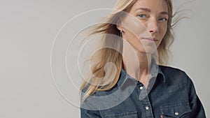 Blonde 30s woman alone in studio wears denim look