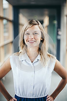 Blonde authentic businesswoman wearing a blouse smiling