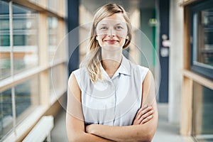 Blonde authentic businesswoman with crossed arms smiling photo