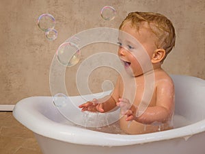 Blonde baby boy meets a soap bubble